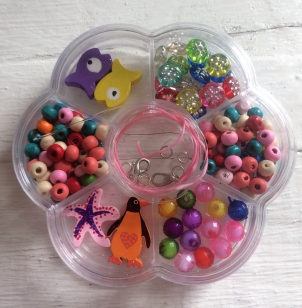 Bead Kit Wood- This is a Lovely Bead Kit for Kids aged 4-10 years old. Ideal for Party Packs or Beginners. The Box is in the shape of a Flower and is Suitable for Girls and Boys. The Kit makes Bracelets and Necklaces. Makes a Lovely Gift.*Kits may vary